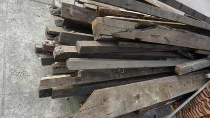 Obsolete piles of wood placed on the side of the road to be transported by transport vehicles
