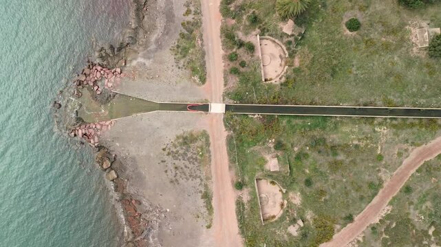 Aerial view, half-circle anti-aircraft gun platforms, coastline inlet
