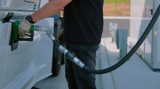 Close up footage of truck driver refuels the semi truck. Petrol station with gas pumps. 