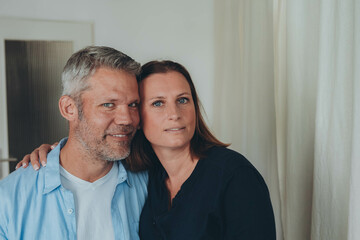 A happy couple is having fun at home while sitting on the floor.