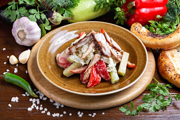 Caesar salad with chicken in a plate against the background of fresh vegetables, on a wooden board. Cafe, lunch, close-up.