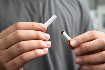 Quit smoking, Asian teenage man breaking destroy cigarette in hand.
