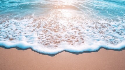 Obraz premium Soft ocean wave gently rolling onto a sandy beach, capturing a peaceful seaside background with clear blue water and golden sand