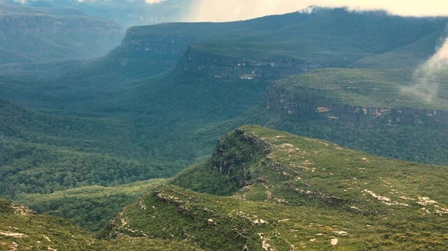 Aerial panoramic establishing overview of Morton National Park with rolling hills, green forests, and expansive wilderness, NSW, Australia