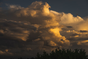 Fototapeta premium Dramatische Wolkenbildung wird von der untergehenden Sonne angestrahlt.