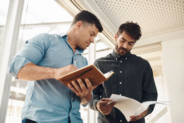 Books, collaboration and documents with business men in office boardroom for discussion....