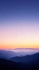 Obraz premium Stunning mountain landscape at dawn, featuring layered hills and a colorful gradient sky.