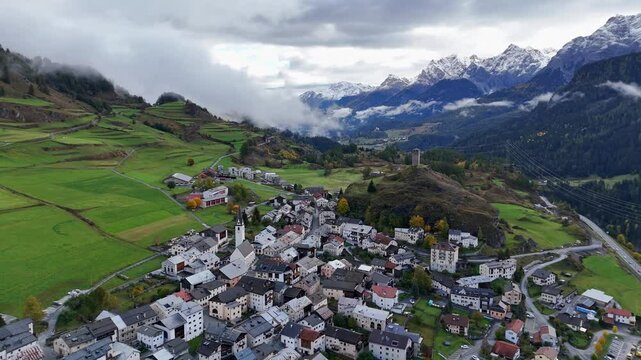 The picturesque swiss village of ardez nestled in the mountains under cloudy skies, aerial view