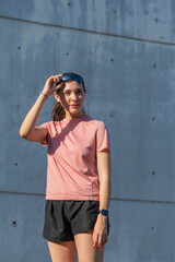 Young Latina woman adjusting sunglasses during outdoor workout