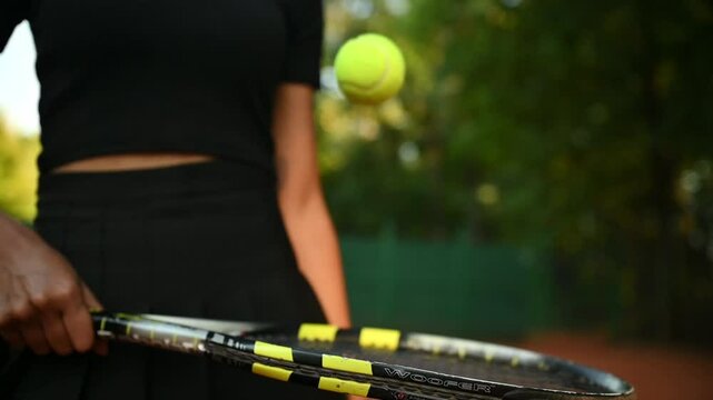 A tennis player plays sports on a tennis court . The athlete trains in tennis. An African girl plays tennis. 