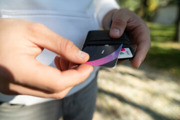 Man holding credit card holder and taking one credit card, business and finance concept, closeup with copy space