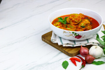 Ayam Rica-Rica, traditional Indonesian hot and spicy braised chicken. White marble background, selected focus.