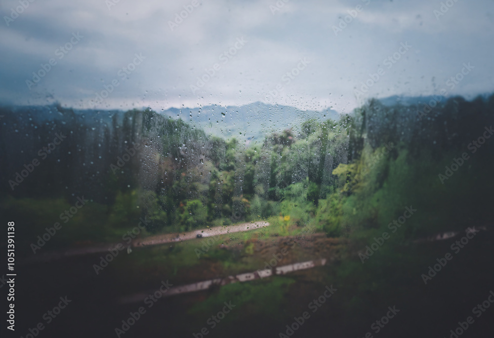Aufkleber a view of a forested valley through a rain-streaked window, with a blurred background of rolling hil