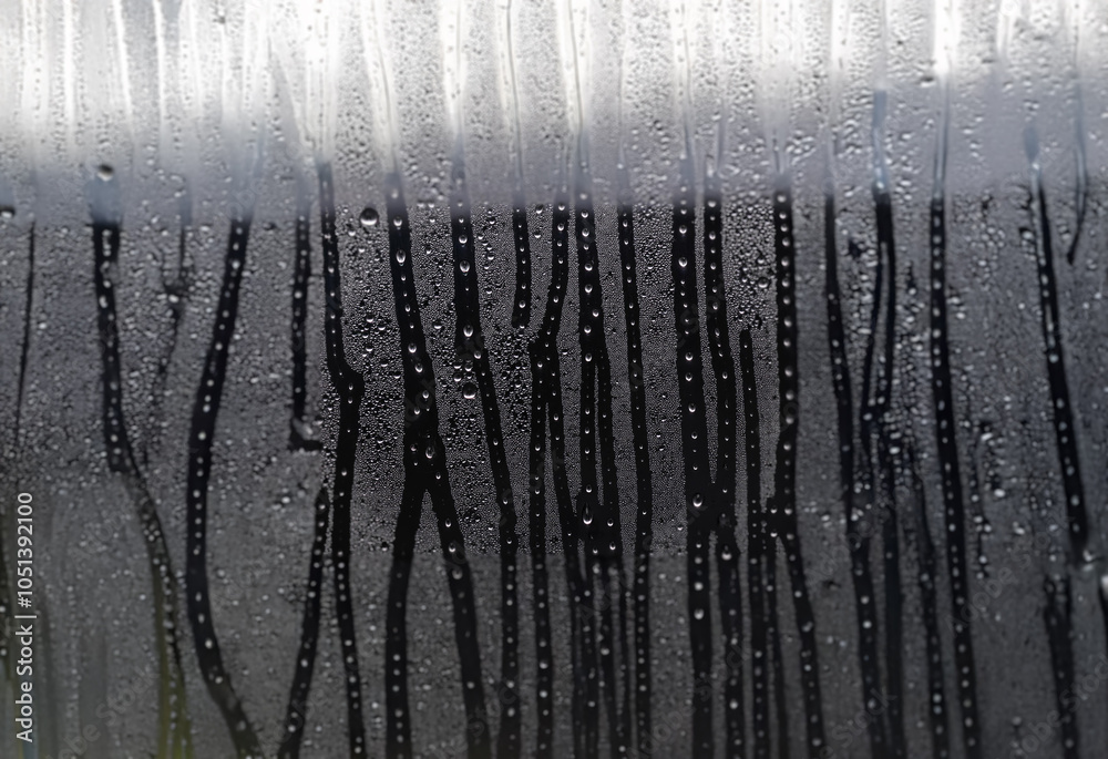 Aufkleber a close-up view of condensation on a window, creating streaks of water and droplets.