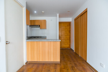 cocina amoblada con alancena ,estufa, muebles altos y bajos , acabados de madera e iluminada
