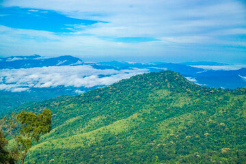 Obraz premium A lush green mountainous landscape under a cloudy sky.