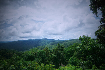 Obraz premium A panoramic view of lush green mountains and valleys under a cloudy sky.
