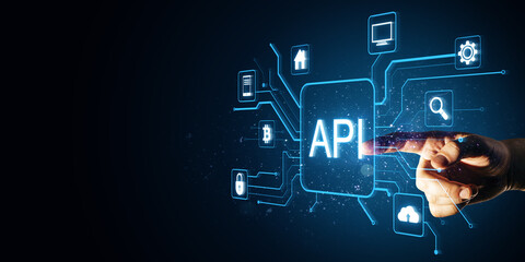 Close up of male hand pointing at glowing api data hologram on blue background with mock up place. Big data, Application programming interface concept.