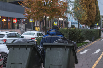 Worker takes out trash bins