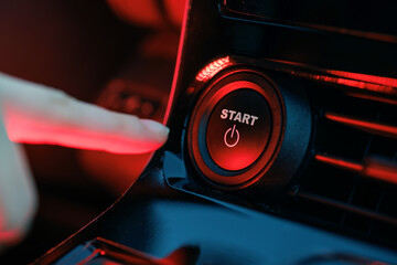 hand pressing start button on car panel, action activation concept