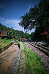 Obraz premium A tranquil railway station in a lush, green setting.