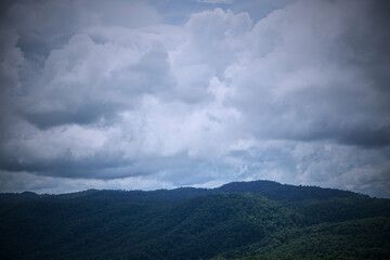 A stunning view of verdant mountains under a cloudy sky.