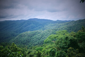 Obraz premium A stunning view of lush green hills under a cloudy sky.