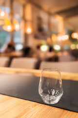 Szklanka stoi na stole, w tyle restauracja 