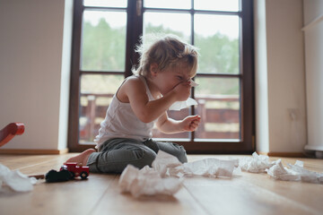 Sick boy with cold has stuffy nose and blowing his nose.