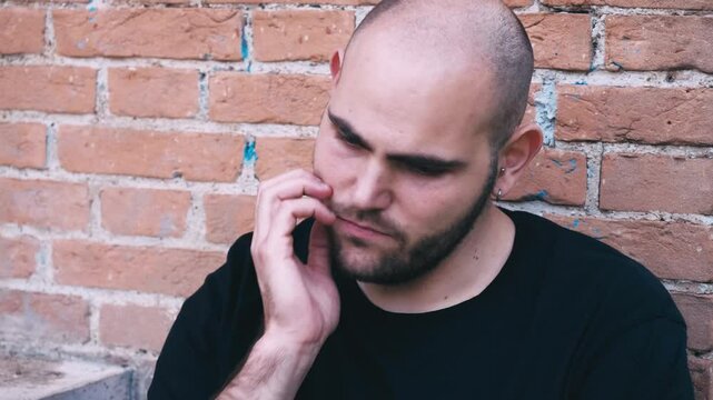 A young man looks extremely sad, feeling hopeless about the future. His expression shows deep inner turmoil and despair.