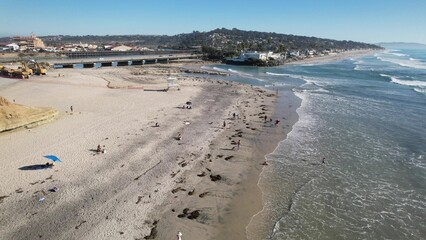 Aerial view of a sandy beach with distant cityscape.