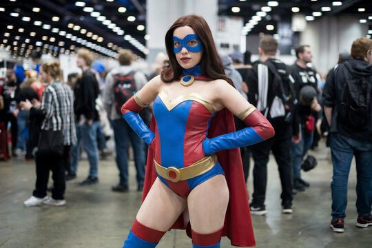 Cosplayer wearing female superhero costume posing at comic convention