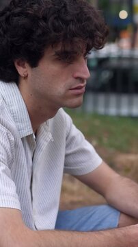 Vertical: A university student sits dejectedly, feeling sad and disappointed after receiving bad results on his exam, reflecting on his performance.