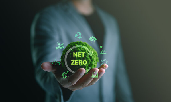 Businessman hand holding globe with Net Zero icon. Climate neutral long term strategy. Decarbonization sustainability, greenhouse gas emissions target, reduce carbon footprint.