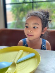 Portrait of a little girl sitting on sofa in a restaurant