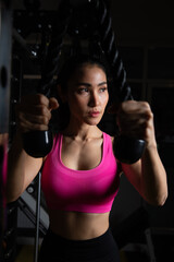 Focused Woman Performing Rope Tricep Extension in Gym, Concentrating on Arm Strength and Muscle Definition During Fitness Workout Session