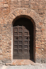 Antique wooden double door in a brick wall.