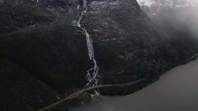 Drone view of the stunning Langfoss waterfall in the fjord with a height of 600 meters. The waterfall is visible from the road.