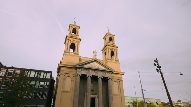 Historic Moses and Aaron Catholic Church located in the heart of Amsterdam. Twin towers and neoclassical architecture stand out against the urban backdrop. Church&rsquo;s grandeur and religious significance
