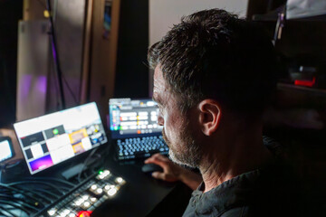 Experienced Mature Male TV Director Operating Control Panel in Studio During Live Streaming Production