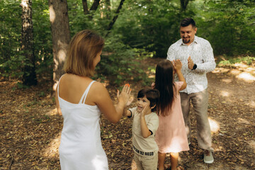 Family with children blow soap bubbles outdoor