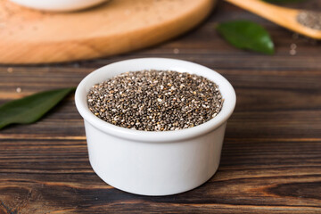 Chia seeds in bowl and spoon on colored background. Healthy Salvia hispanica in small bowl. Healthy superfood