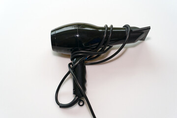 Top view of black hairdryer with cable against white background. Photo taken October 28th, 2024, Zurich, Switzerland.