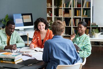 Group of diverse colleagues working together on project around table, sharing ideas and engaging in...