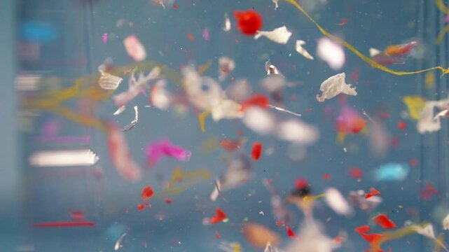 Swirling microplastics in water, a slow-motion capture of environmental contamination for lab research on waste pollution.