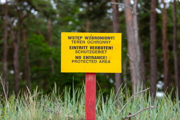 Multilingual Warning Sign Prohibiting Entry to Protected Natural Area Amidst Forest