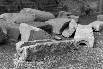 A collection of carved stone blocks lie in a pile on the ground