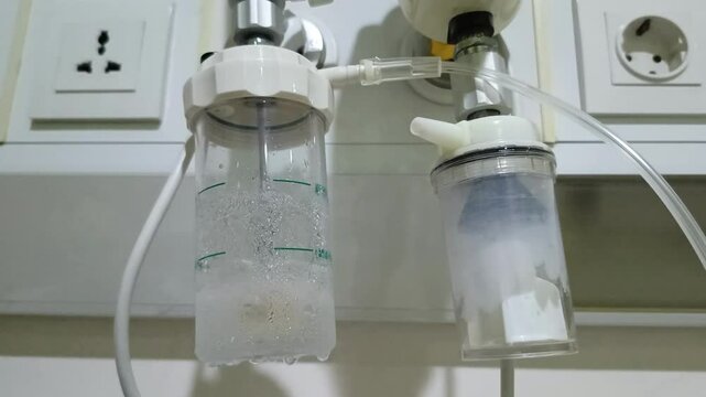 close up of the flow tube of the oxygen water filter bubble O2 beside the tube scale to help the patient's breathing in the hospital room. for health, education, technology content