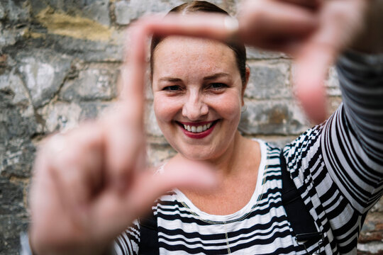 Smiling woman gesturing hand frame