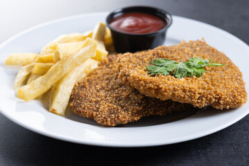 Cachopo, Traditional food in Asturias, Spain. Breaded fillet meat on black slate background